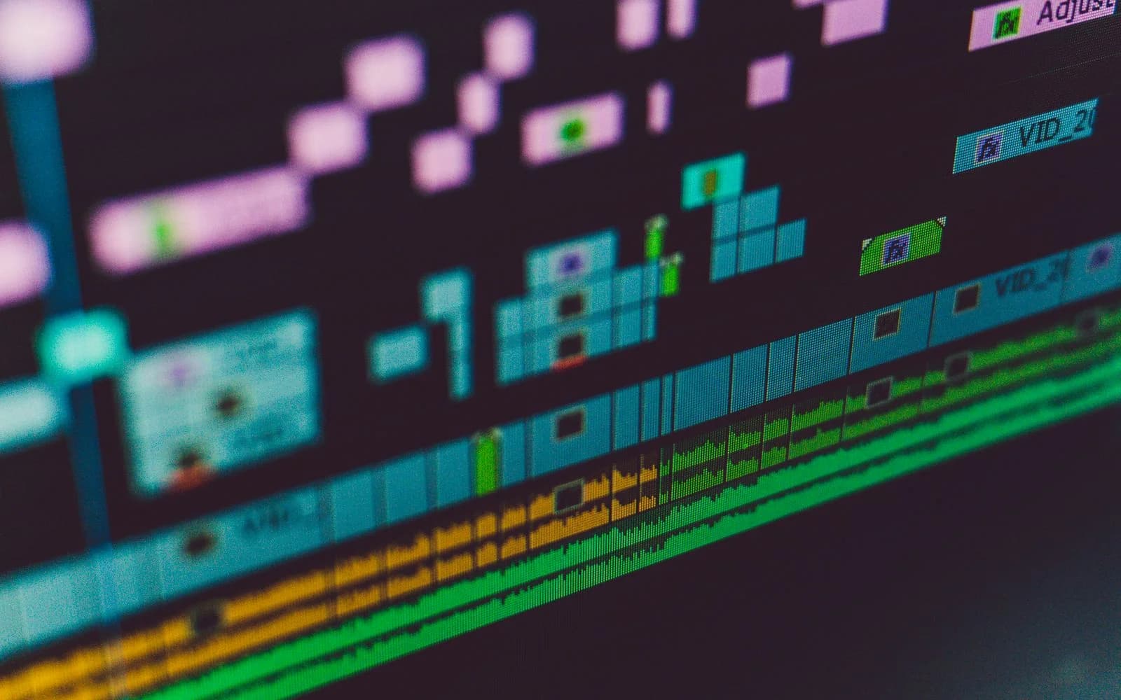 Nahaufnahme einer Videoschnitt-Timeline mit mehreren farbigen Spuren auf einem Bildschirm